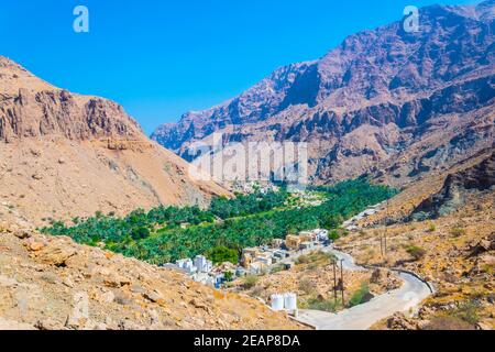 Vue aérienne d'un village entouré d'une forêt de palmiers dans le Wadi Tiwi en Oman. Banque D'Images