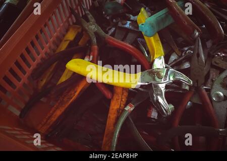 Anciennes pinces dans un panier en plastique. Outil d'occasion à vendre sur le marché des outils. Vieille pince dans le plateau à outils boîte à outils de handyman. Outils à main mécaniques. Outils utilisés sur le marché des outils d'occasion, en Thaïlande. Beaucoup de pinces. Banque D'Images