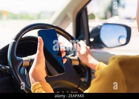 femme à l'intérieur d'une voiture et à l'aide d'une main tenant mobile smartphone Banque D'Images