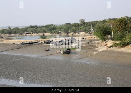 Des bateaux de pêcheurs se sont toronnés dans la boue à marée basse sur la rivière Matla près de Canning Town, en Inde Banque D'Images