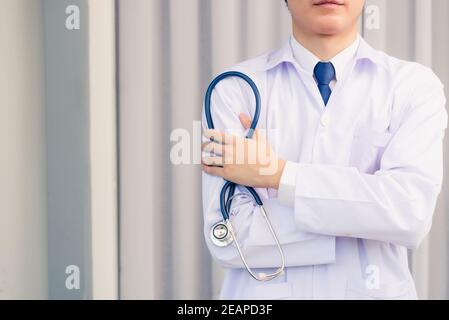 Portrait médecin homme souriant bras croisés tenir stéthoscope Banque D'Images