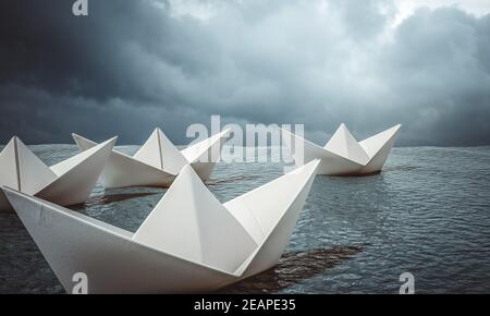 groupe de bateaux en papier naviguant dans l'océan. Banque D'Images