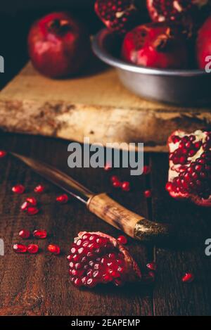 Fruits de grenade avec couteau sur table en bois Banque D'Images