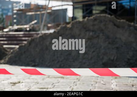 Lignes rouges et blanches de ruban de protection avertissant de danger pendant la construction et la réparation des bâtiments. Avertissement rouge et blanc la protection de la tige en ruban protège contre la pénétration Banque D'Images