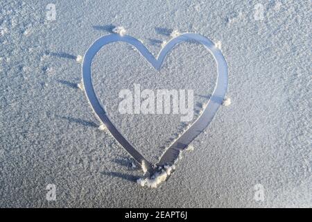 Coeur dessiné dans le givre sur le capot de la voiture Banque D'Images