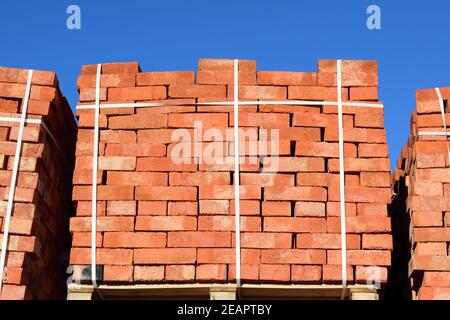 Des briques rouges superposés en cubes. Les briques de l'entrepôt. Produits de stockage briqueterie Banque D'Images