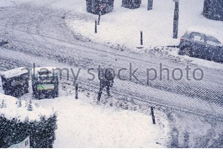 Édimbourg, Écosse, Royaume-Uni. 10 février 2021. Une douche à neige épaisse en fin d'après-midi donne aux rues résidentielles une couche supplémentaire de neige. Piéton en difficulté avec leur pied. Crédit : Craig Brown/Alay Live News Banque D'Images