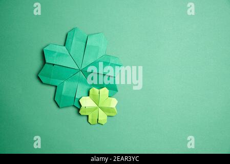 Paire de trèfle à quatre feuilles d'origami, en papier vert, sur fond vert. Concepts de chance et de la Saint-Patrick. Image avec espace de copie. Banque D'Images