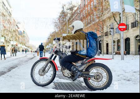 Homme avec moto dans la rue avec de la neige Banque D'Images