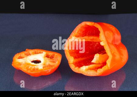 Le poivron doux vide repose sur une table en verre avec réflexion. Produits de l'alimentation sur fond noir Banque D'Images