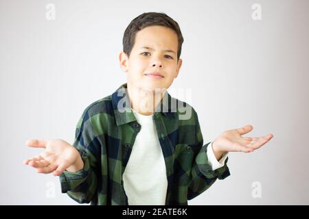 Gros plan portrait d'un petit garçon confus sans clume, bras dehors demandant ce qui est le problème qui se soucie de ce que, Je ne sais pas. Expr. Faciale d'émotion humaine négative Banque D'Images