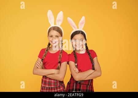 Équipe de Bunny. Concept de divertissement et d'événement. Vacances de printemps. Enfants dans les oreilles de lapin de lapin. Famille et Sisterhood. Uniforme scolaire pour petites écolières avec de longues oreilles de lapin. Jeux traditionnels de Pâques. Banque D'Images