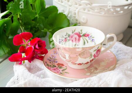 Tasse rétro rose vintage avec fleur de géranium sur fond blanc serviette de table Banque D'Images