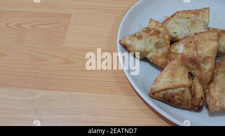 Gros plan de délicieux plats faits maison de samosa ou de pâtisseries arrière-plan blanc Banque D'Images