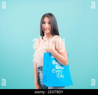 une femme debout sourit qu'elle porte un sac de coton en tissu écologique main Banque D'Images