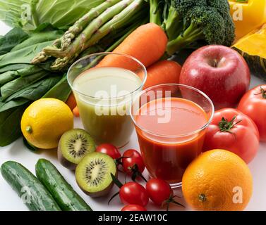 Beaucoup de fruits et légumes sur fond blanc avec un verre de smoothie vert et de jus de légumes Banque D'Images