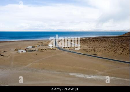 Un village près d'un lac tibétain et une route vers lui. Banque D'Images