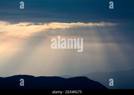 Poutres de soleil sur des contreforts de l'Himalaya silhouettés, au sud de la chaîne Annapurna. Népal. Banque D'Images