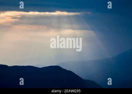 Poutres de soleil sur des contreforts de l'Himalaya silhouettés, au sud de la chaîne Annapurna. Népal. Banque D'Images