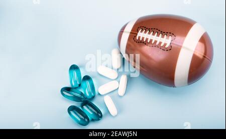 Équipement de sport, oeuf sous forme de ballon de football avec des pilules de médicaments et des suppléments alimentaires. Espace pour le texte. Banque D'Images