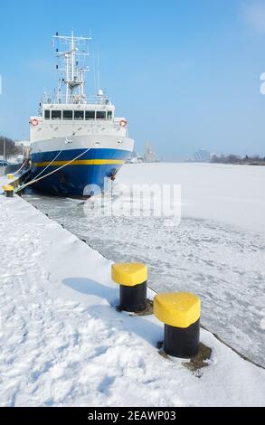 Amarrer des bollards sur un quai par la rivière Odra gelée à Szczecin, Pologne. Banque D'Images