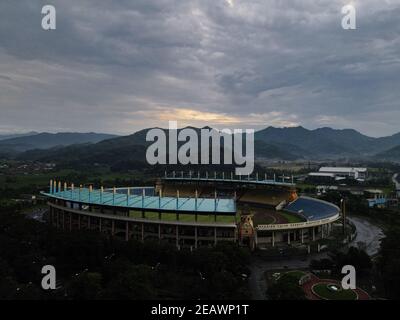 Vue aérienne du stade de football de Bandung City, Indonésie. Coucher de soleil ou lever de soleil et nuage de bruit. Tir de drone. Bandung, Indonésie - 11 février 2021 Banque D'Images