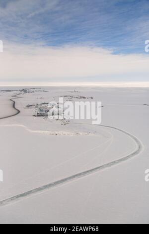 Vue aérienne de la zone industrielle du hameau arctique Tuktoyaktuk en hiver entouré par l'océan Arctique gelé, Territoires du Nord-Ouest, Canada. Banque D'Images