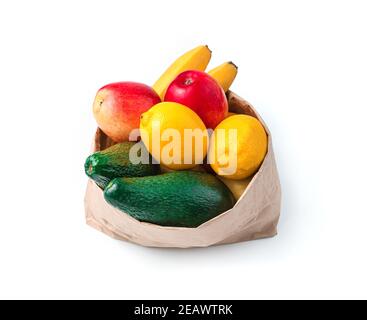 Avocats, citrons, bananes et pommes dans un sac en papier isolé sur fond blanc. Banque D'Images