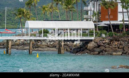 Airlie Beach, Queensland, Australie - février 2021 : une jetée touristique dans un hôtel côtier de luxe avec des bateaux sur l'eau et des touristes se détendant dans le su Banque D'Images