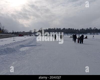 Patineurs sur la plus longue patinoire du monde, profitant d'une belle journée de week-end d'hiver. Canal Rideau, Ottawa (Ontario), Canada. Banque D'Images