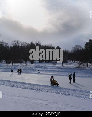 Patineurs sur la plus longue patinoire du monde, profitant d'une belle journée de week-end d'hiver. Canal Rideau, Ottawa (Ontario), Canada. Banque D'Images