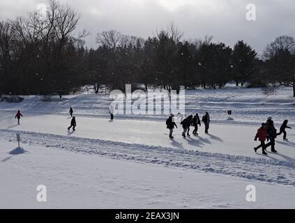 Patineurs sur la plus longue patinoire du monde, profitant d'une belle journée de week-end d'hiver enneigée. Canal Rideau, Ottawa (Ontario), Canada. Banque D'Images