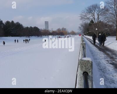 Patineurs ( et marcheurs) sur (et par) la plus longue patinoire du monde bénéficiant d'un beau temps d'hiver. Canal Rideau, Ottawa (Ontario), Canada. Banque D'Images