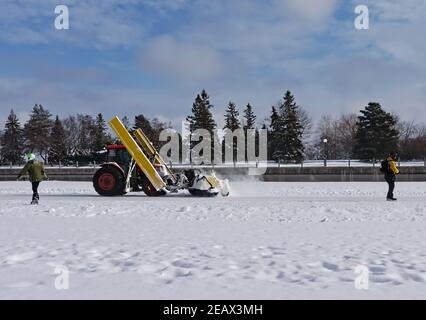 Les patineurs font place à la chasse-neige qui nettoie la surface de patinage sur le canal Rideau pendant le Bal de neige. Ottawa, Ontario, Canada. Banque D'Images