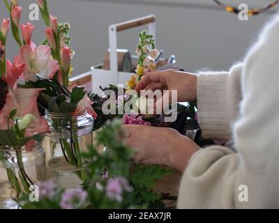 les mains du fleuriste au travail font un bouquet floral Banque D'Images