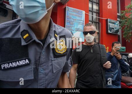 Badung, Bali, Indonésie. 10 février 2021. DAVID TAYLOR (c) escorté par un agent d'immigration. DAVID TAYLOR, également connu sous le nom de 'DJ NUTZO', citoyen britannique qui a tué un policier de Bali WAYAN SUDIARSA en 2016 libéré après avoir été emprisonné pendant 5 ans à la prison de Kerobokan. Sa petite amie, Sara CONNOR, qui sont toutes deux condamnées pour voies de fait mortelles, a été libérée le 2020 juillet. (Credit image: © Dicky BisinglasiZUMA Wire) Credit: ZUMA Press, Inc./Alamy Live News Banque D'Images