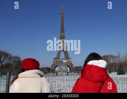 Paris, France. 10 février 2021. Les gens voient les paysages après les chutes de neige au champ de Mars à Paris, France, le 10 février 2021. Douze régions de France ont été mises en alerte orange en raison de chutes de neige et de glace suite à un « épisode de neige pouvant être signalé » qui a frappé les départements du nord-est du pays, a déclaré mercredi l'agence météorologique Meteo France. Credit: Gao Jing/Xinhua/Alamy Live News Banque D'Images