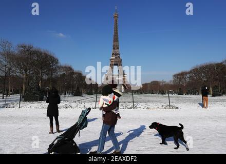 Paris, France. 10 février 2021. Les gens se promètrent après les chutes de neige au champ de Mars à Paris, France, le 10 février 2021. Douze régions de France ont été mises en alerte orange en raison de chutes de neige et de glace suite à un « épisode de neige pouvant être signalé » qui a frappé les départements du nord-est du pays, a déclaré mercredi l'agence météorologique Meteo France. Credit: Gao Jing/Xinhua/Alamy Live News Banque D'Images