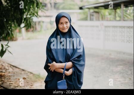 Femme musulmane thaïlandaise portant une robe hijab bleue, souriant. Banque D'Images