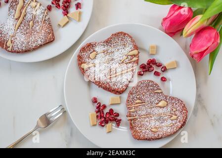 crêpes en velours rouge en forme de coeur sur une table Banque D'Images