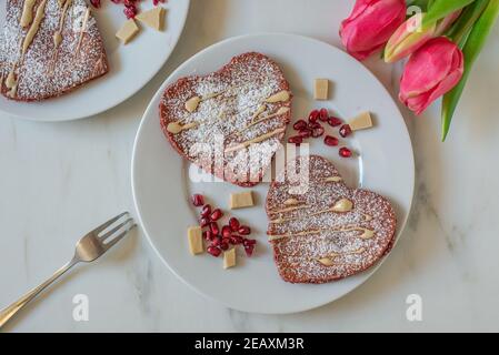 crêpes en velours rouge en forme de coeur sur une table Banque D'Images