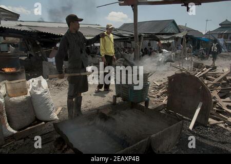 Un travailleur qui fait bouillir des moules vertes dans une zone de production à Kamal Muara, Jakarta, Indonésie. Banque D'Images