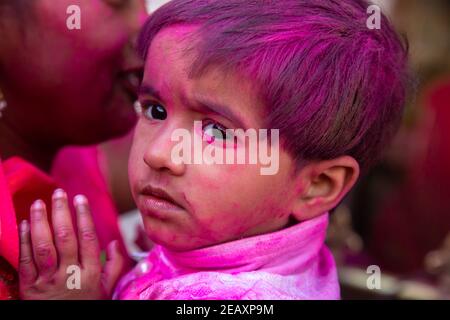 Jodhpur, rajastha, inde - 20 mars 2020 : petit visage indien mignon couvert de poudre de couleur rose. Célébration du festival holi Banque D'Images