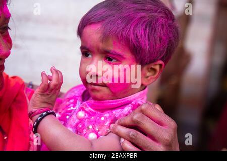 Jodhpur, rajastha, inde - 20 mars 2020 : petit visage indien mignon couvert de poudre de couleur rose. Célébration du festival holi Banque D'Images