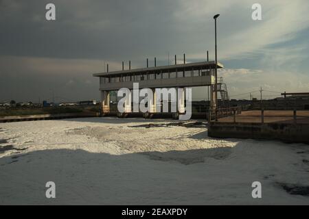 Des mousses blanches couvrent une voie navigable à proximité d'une partie de l'autoroute menant à l'aéroport international Soekarno-Hatta de Jakarta, dans la zone côtière de Jakarta, en Indonésie. Banque D'Images