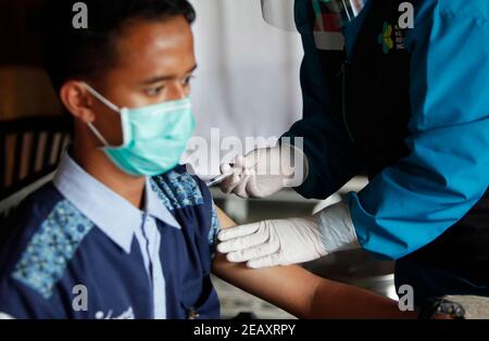 Bogor, Indonésie. 11 février 2021. Une travailleuse de la santé vaccine sa collègue lors d'une vaccination de masse des travailleurs de la santé et des travailleurs de la santé âgés à Bogor, dans l'ouest de Java, le 11 février 2021. (Photo par Adrian/INA photo Agency/Sipa USA) crédit: SIPA USA/Alay Live News Banque D'Images