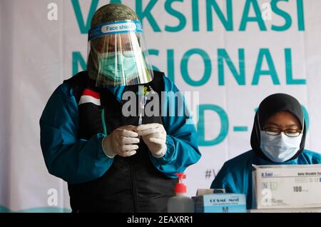 Bogor, Indonésie. 11 février 2021. Une travailleuse de la santé prépare la vaccination de sa collègue lors d'une vaccination de masse des travailleurs médicaux et des travailleurs de la santé âgés à Bogor, dans l'ouest de Java, le 11 février 2021. (Photo par Adrian/INA photo Agency/Sipa USA) crédit: SIPA USA/Alay Live News Banque D'Images