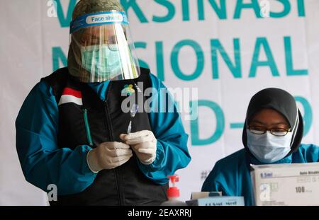 Bogor, Indonésie. 11 février 2021. Une travailleuse de la santé prépare la vaccination de sa collègue lors d'une vaccination de masse des travailleurs médicaux et des travailleurs de la santé âgés à Bogor, dans l'ouest de Java, le 11 février 2021. (Photo par Adrian/INA photo Agency/Sipa USA) crédit: SIPA USA/Alay Live News Banque D'Images