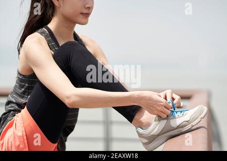 jeune femme asiatique en vêtements de sport laçage avant de faire de l'exercice Banque D'Images