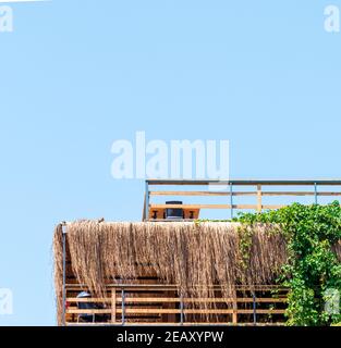 Toit en Tatched sur la table et la chaise avec le ciel bleu vue Banque D'Images